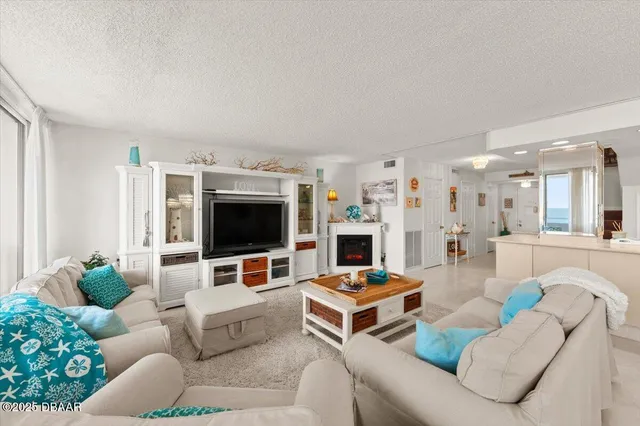 a living room with furniture a chandelier and a dining table