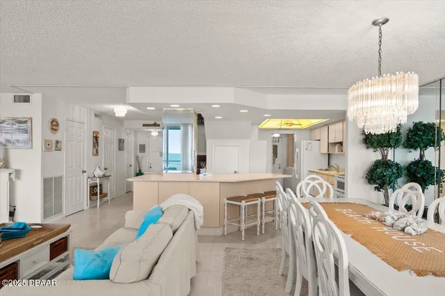 a living room with furniture a flat screen tv and a chandelier