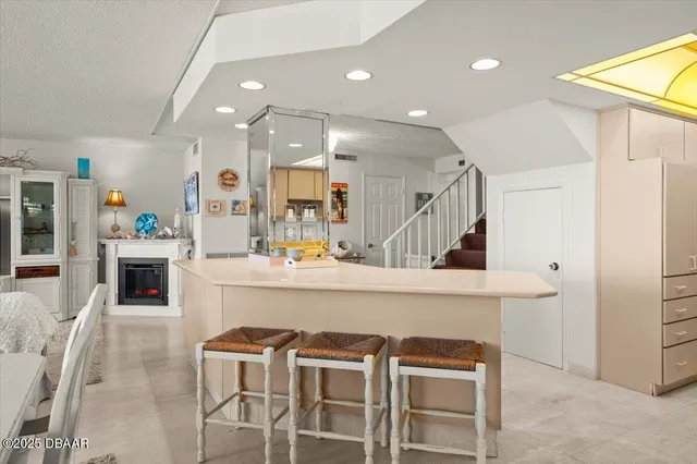 a kitchen with stainless steel appliances kitchen island granite countertop a refrigerator and a sink