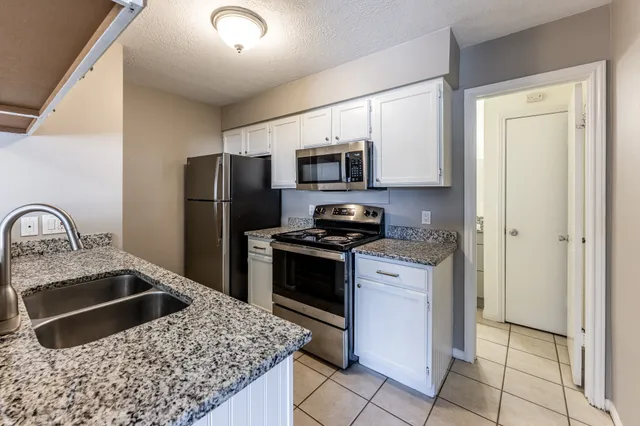 a kitchen with stainless steel appliances granite countertop a refrigerator sink and stove