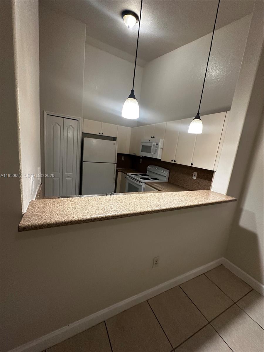2903 Southeast 17th Avenue, Unit 209 Homestead, FL 33035 - Photo 11 of 30 a kitchen with a refrigerator a sink and wooden floor