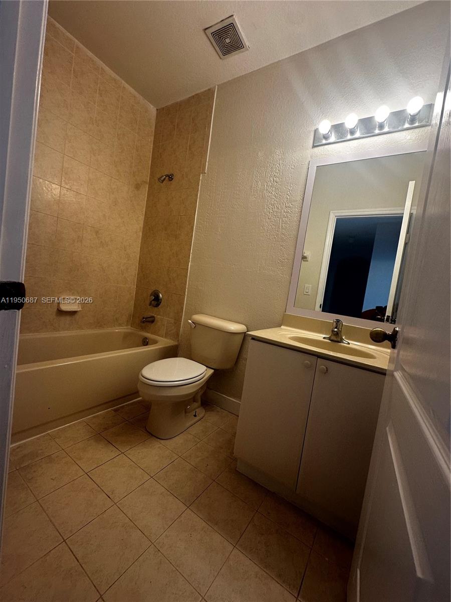 2903 Southeast 17th Avenue, Unit 209 Homestead, FL 33035 - Photo 22 of 30 a bathroom with a toilet a sink and mirror