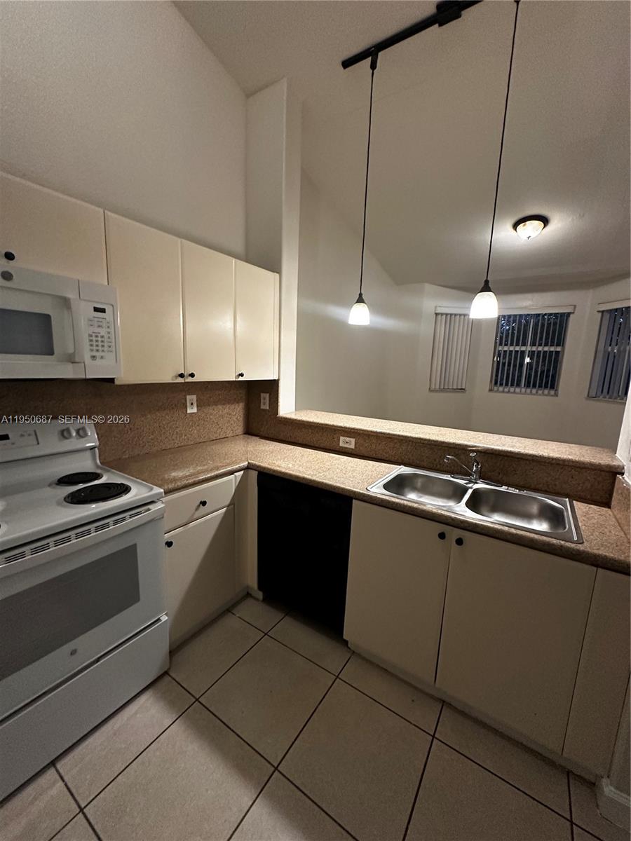 2903 Southeast 17th Avenue, Unit 209 Homestead, FL 33035 - Photo 10 of 30 a large kitchen with stainless steel appliances a stove a sink a counter space and cabinets