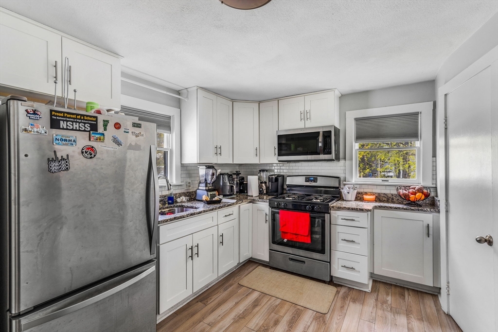 145 Maple Street Danvers, MA 01923 - Photo 15 of 27 a kitchen with stainless steel appliances a stove refrigerator sink and microwave