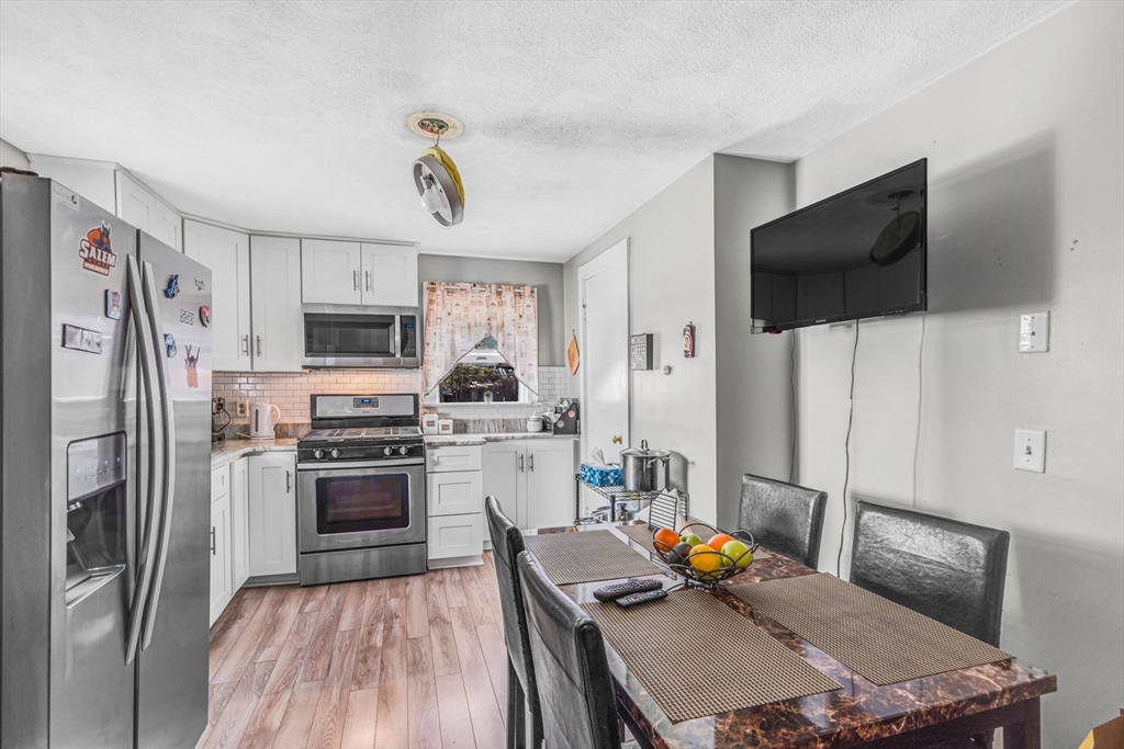 145 Maple Street Danvers, MA 01923 - Photo 7 of 27 a kitchen with stainless steel appliances a stove a refrigerator and a sink