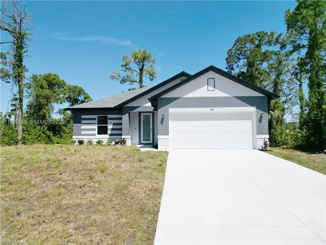 a front view of a house with a yard and garage