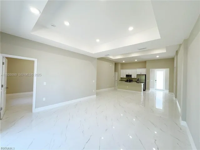a view of empty room with kitchen view