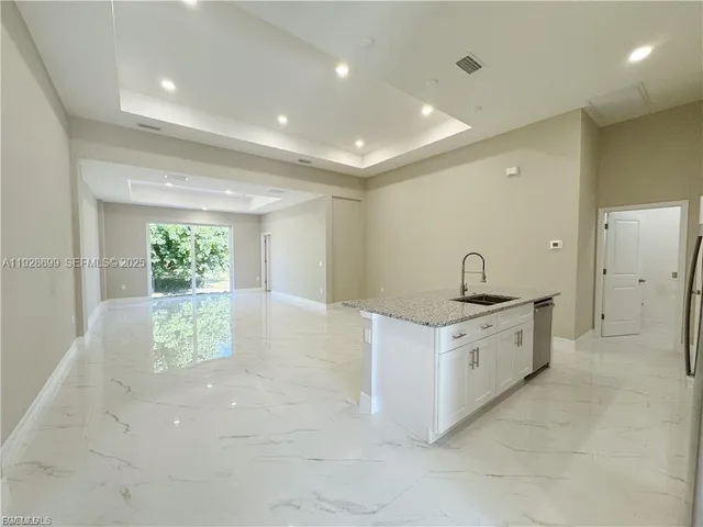 a large bathroom with a granite countertop sink a toilet a large mirror and shower