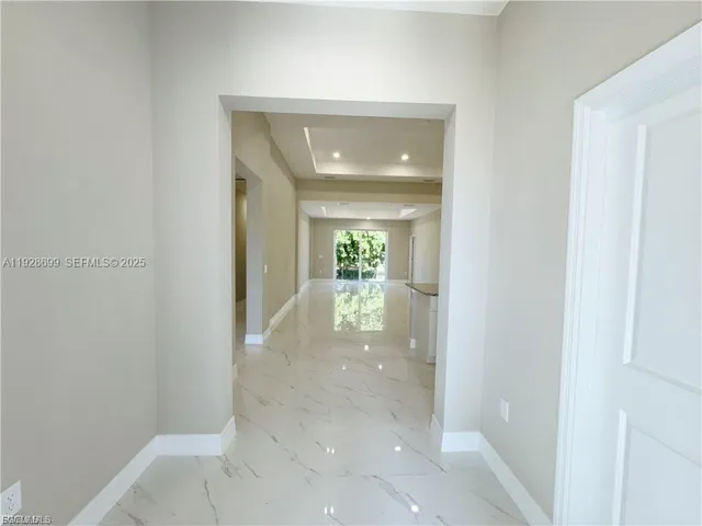 a view of a hallway with wooden floor table and chair