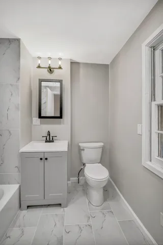 a bathroom with a toilet sink and mirror