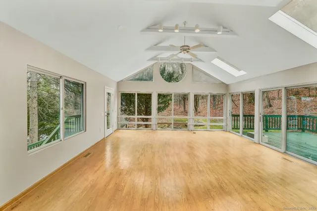 a view of an empty room with a chandelier fan and large windows