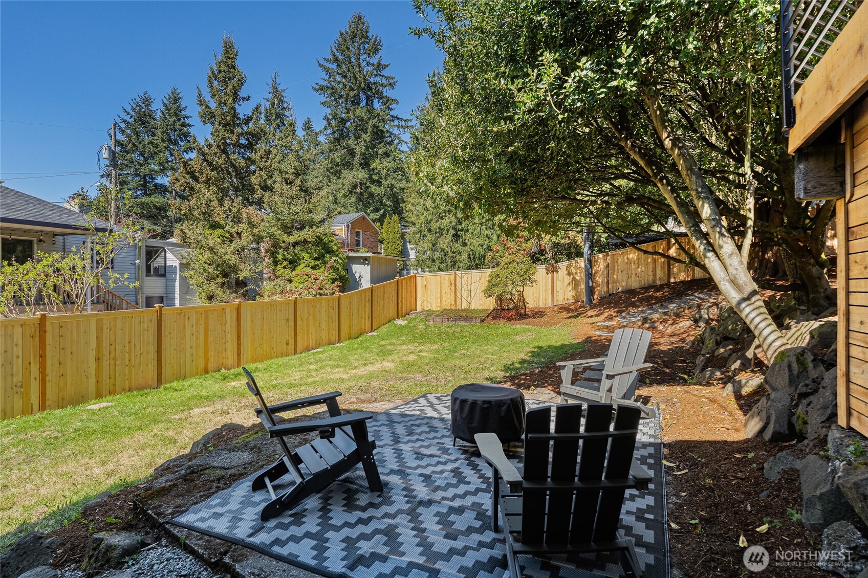 1710 Northeast 104th Street Seattle, WA 98125 - Photo 36 of 40 a view of a backyard with table and chairs potted plants and large tree