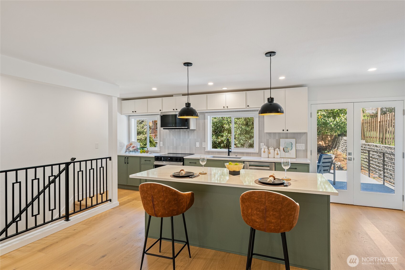 1710 Northeast 104th Street Seattle, WA 98125 - Photo 4 of 40 a kitchen with stainless steel appliances granite countertop a sink a stove a dining table and chairs with wooden floor