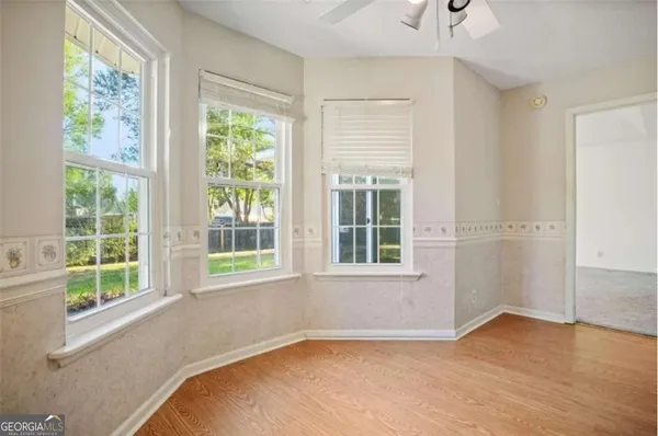 a view of an empty room with a window and wooden floor
