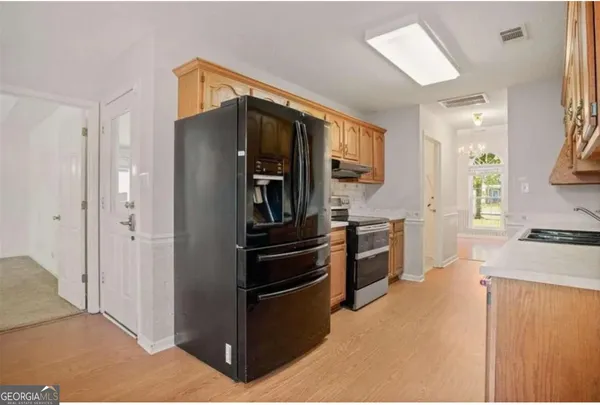 a kitchen with a refrigerator and a stove top oven