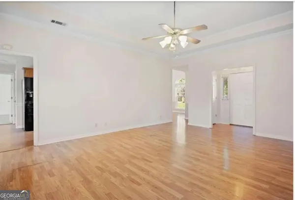 a view of an empty room with wooden floor
