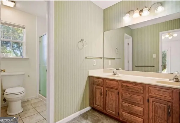 a bathroom with a granite countertop sink mirror and toilet