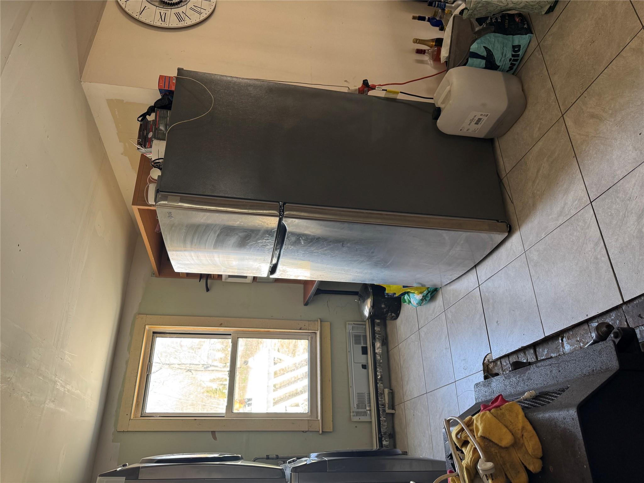 50 Hamilton Road Bloomingburg, NY 12721 - Photo 12 of 33 Kitchen featuring light tile patterned flooring, stacked washer / dryer, and freestanding refrigerator
