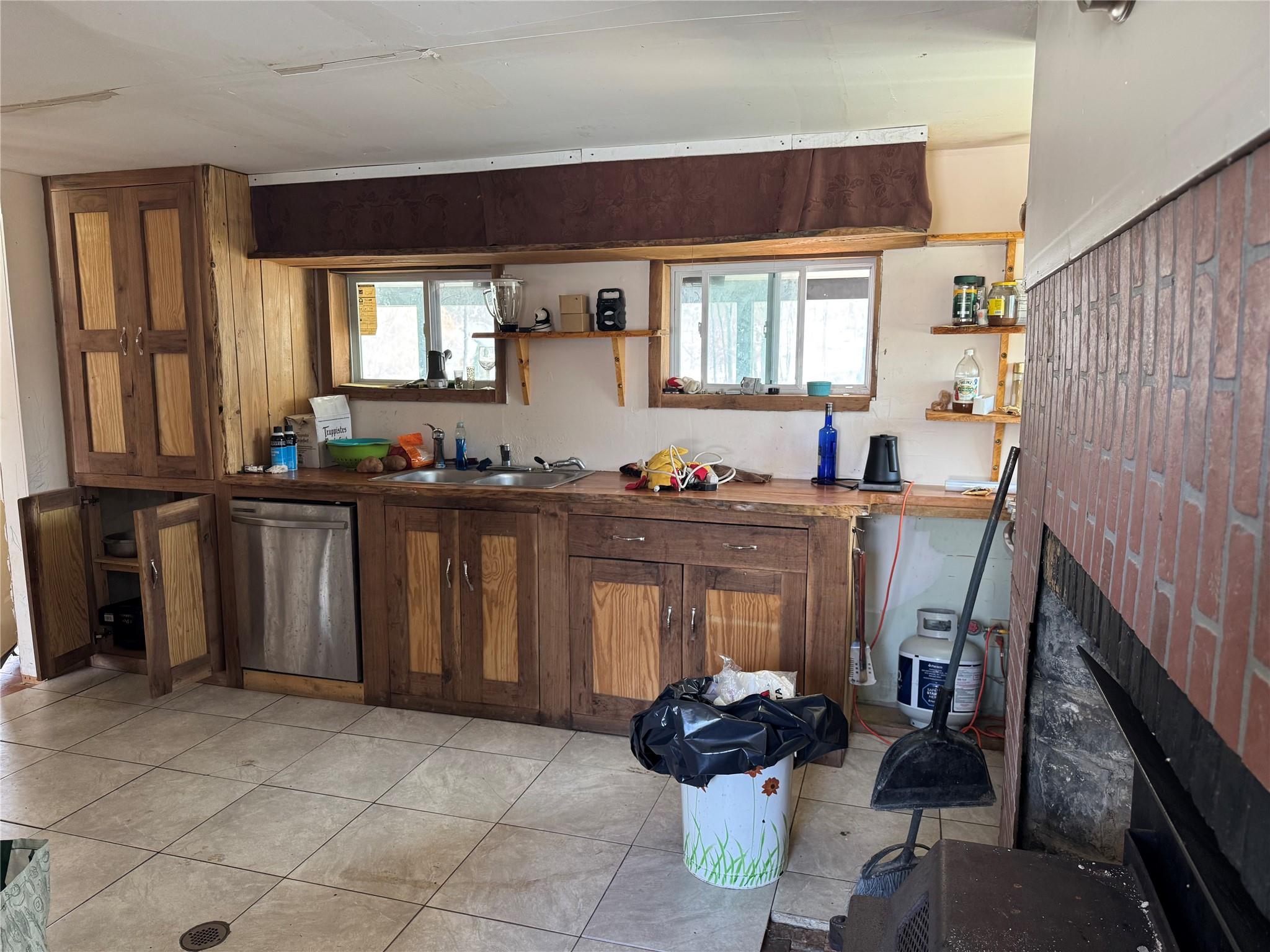 50 Hamilton Road Bloomingburg, NY 12721 - Photo 15 of 33 Kitchen featuring open shelves, dishwasher, a brick fireplace, and a sink