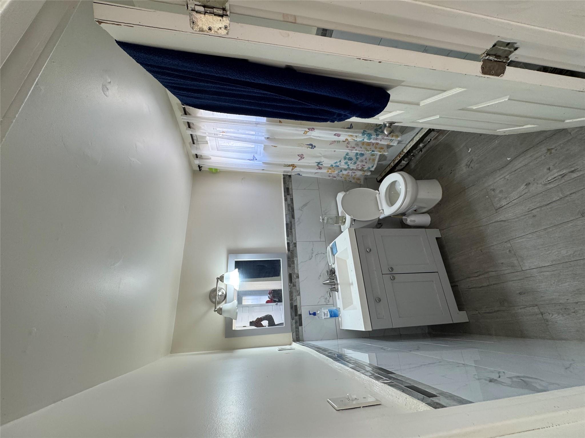 50 Hamilton Road Bloomingburg, NY 12721 - Photo 19 of 33 Full bathroom featuring a wainscoted wall, toilet, tile walls, wood finished floors, and vanity