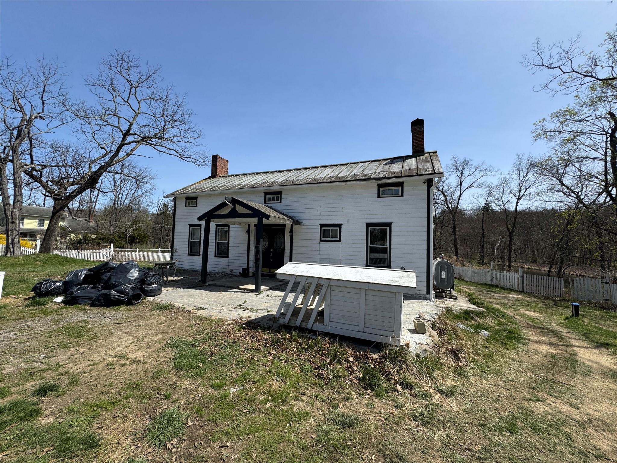 50 Hamilton Road Bloomingburg, NY 12721 - Photo 2 of 33 Back of property featuring metal roof, a chimney, and fence