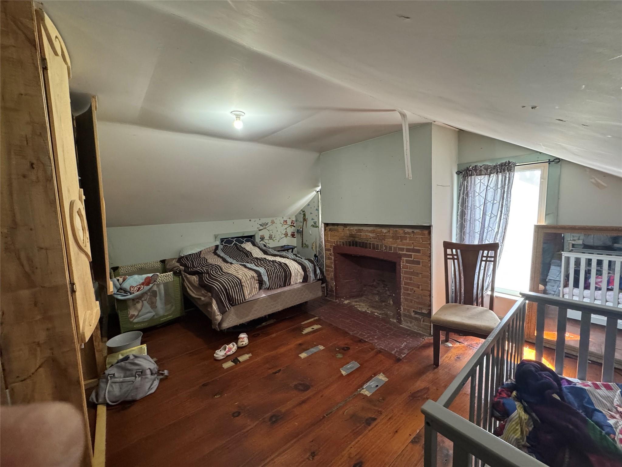 50 Hamilton Road Bloomingburg, NY 12721 - Photo 24 of 33 Bedroom featuring lofted ceiling, a brick fireplace, and hardwood / wood-style flooring