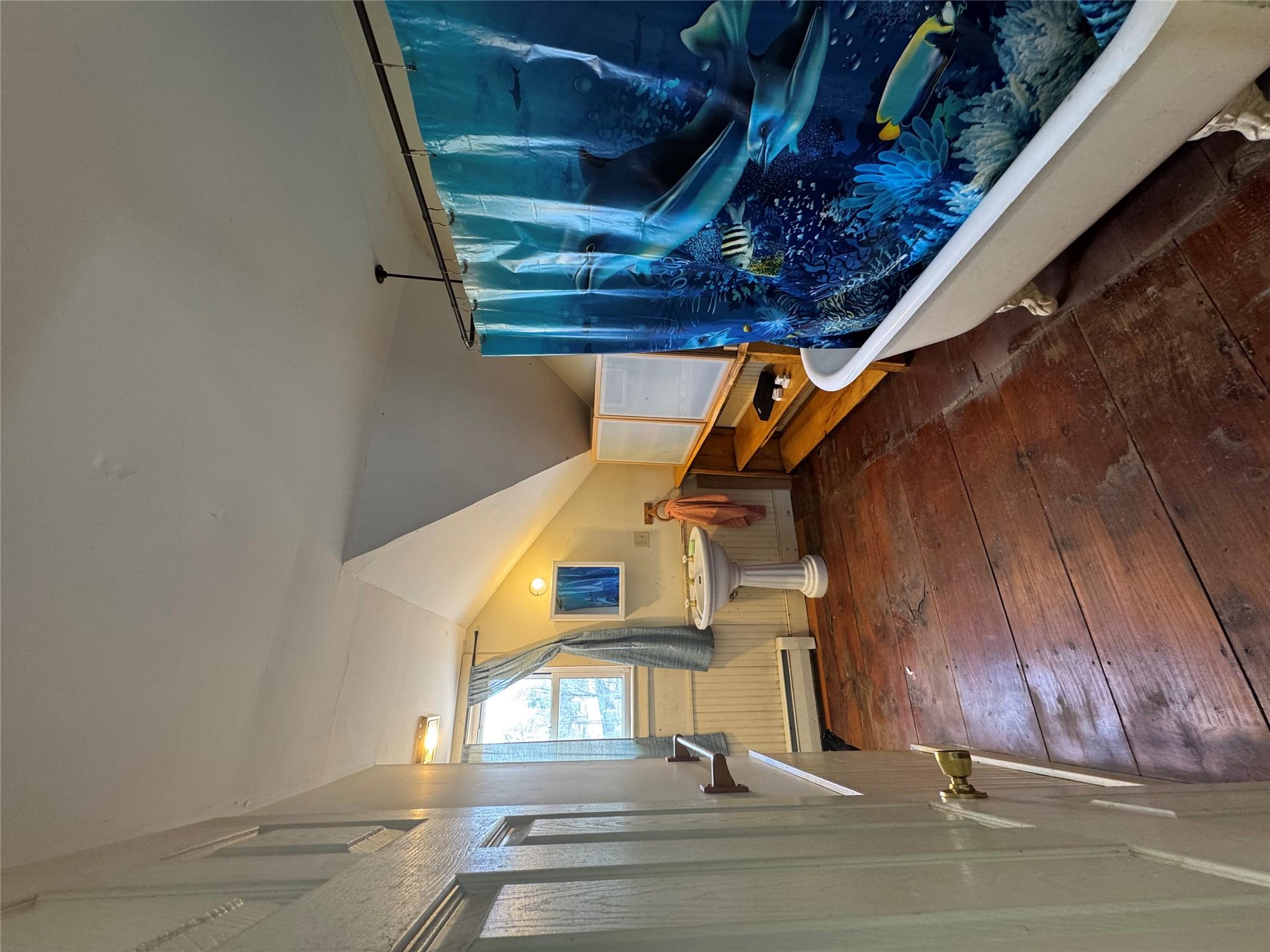 50 Hamilton Road Bloomingburg, NY 12721 - Photo 27 of 33 Bathroom with lofted ceiling, baseboard heating, a freestanding tub, curtained shower, and wood-type flooring