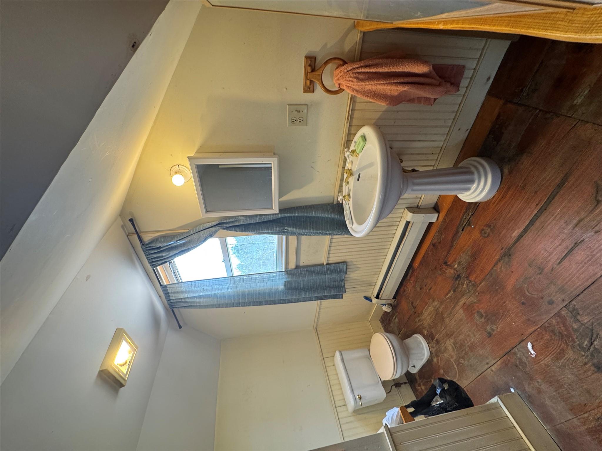 50 Hamilton Road Bloomingburg, NY 12721 - Photo 28 of 33 Half bathroom with toilet, wainscoting, lofted ceiling, baseboard heating, and hardwood / wood-style floors