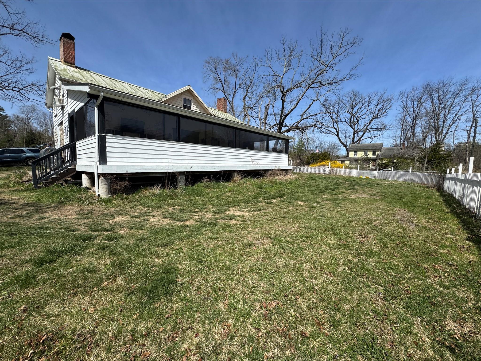 50 Hamilton Road Bloomingburg, NY 12721 - Photo 32 of 33 Back of property featuring a chimney, fence, a yard, metal roof, and a sunroom