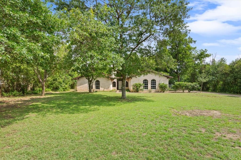317 Chapman Road Hewitt, TX 76643 - Photo 6 of 20 Expansive front lawn featuring mature trees and a brick exterior with arched windows
