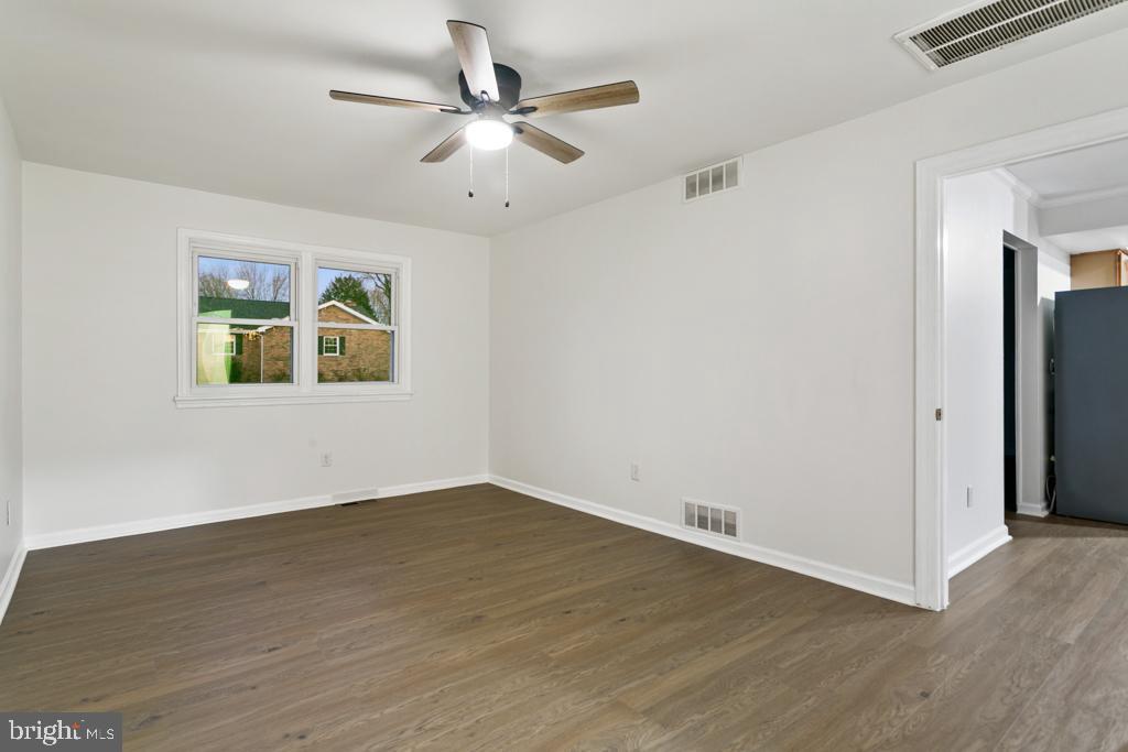 9 Oberlin Road Pennsville, NJ 08070 - Photo 19 of 23 an empty room with wooden floor ceiling fan and windows