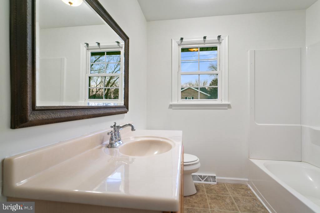 9 Oberlin Road Pennsville, NJ 08070 - Photo 10 of 23 a white bath tub sitting next to a white sink and a toilet