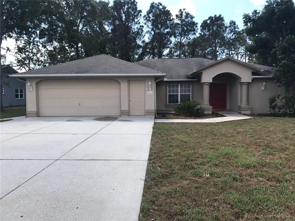 10410 Lear Street Spring Hill, FL 34608 - Photo 1 of 1 a front view of a house with garden