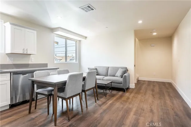a living room with furniture a window and wooden floor