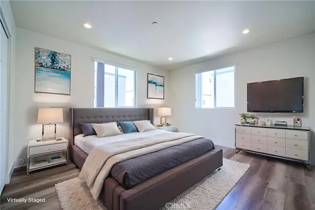 a bedroom with bed flat screen tv and window