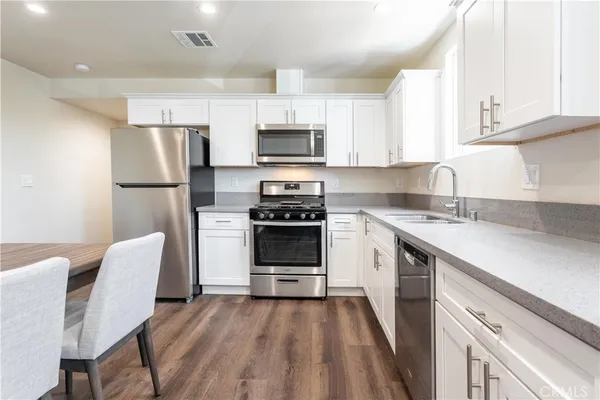 a kitchen with cabinets stainless steel appliances a sink and a stove