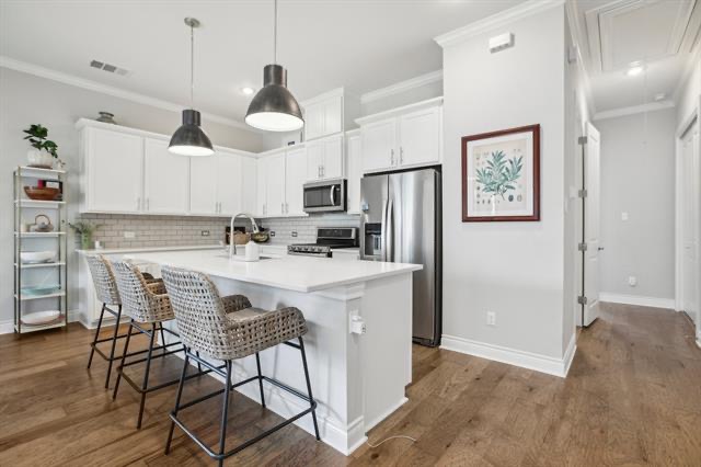 332 Adams Street Georgetown, TX 78628 - Photo 9 of 37 Culinary delights await in this bright kitchen with an inviting island and rich hardwood flooring.