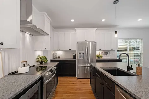 a kitchen with a sink stainless steel appliances a counter top space cabinets and stainless steel appliances