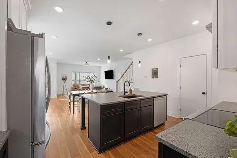 a kitchen with stainless steel appliances granite countertop a sink stove and refrigerator