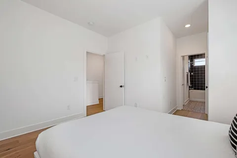 a bedroom with a bed and wooden floor