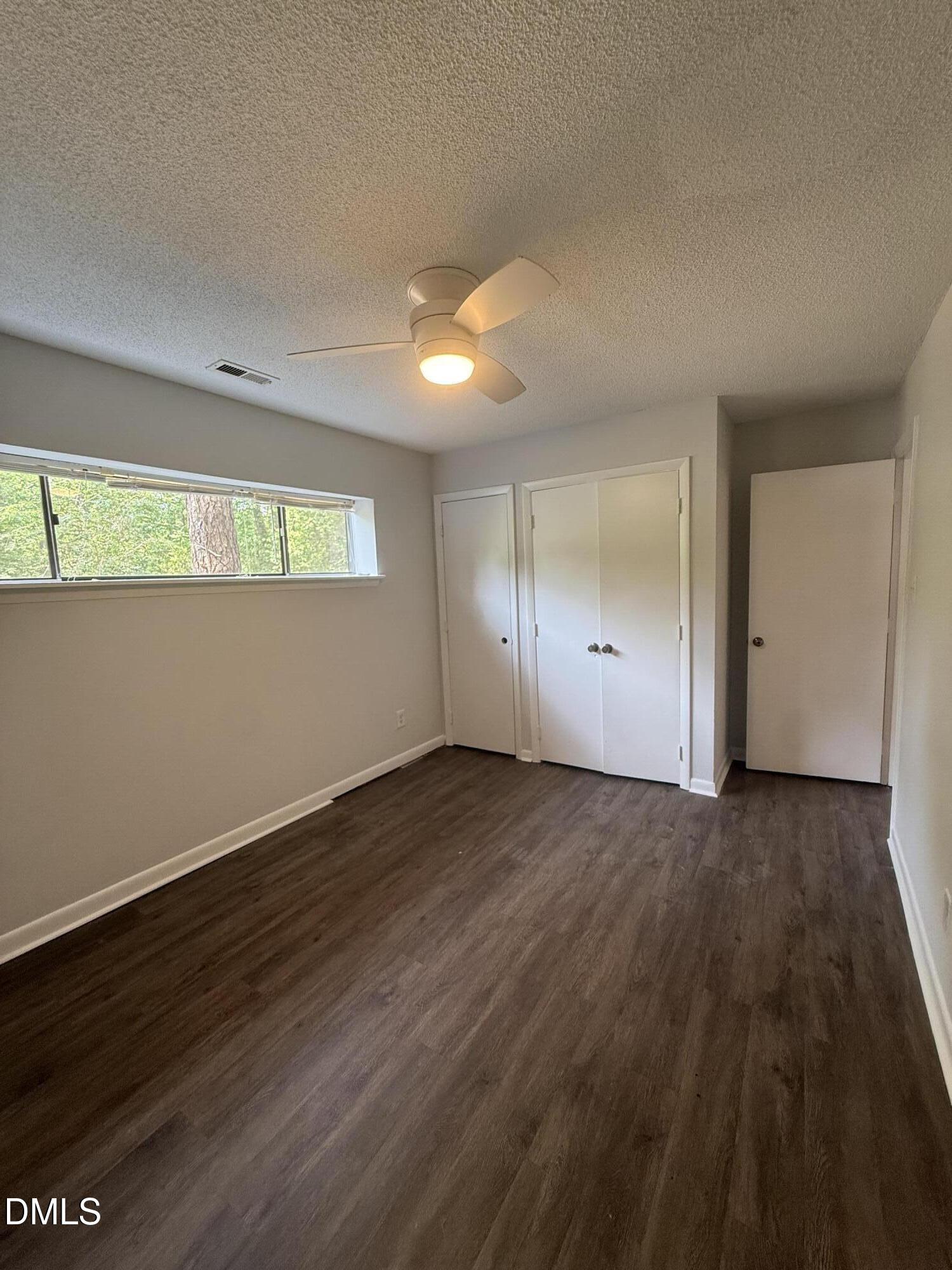 546 Pine Ridge Place Raleigh, NC 27609 - Photo 16 of 28 an empty room with wooden floor and windows