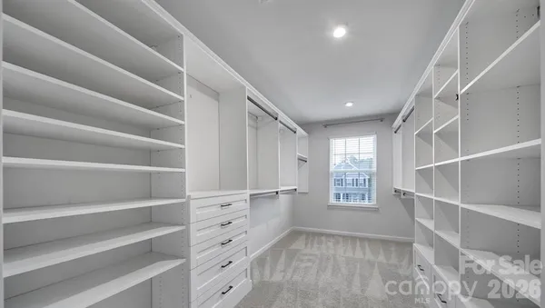 a view of walk in closet with empty racks