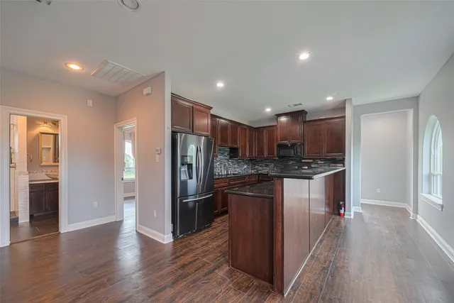 a kitchen with stainless steel appliances granite countertop a refrigerator and a stove top oven