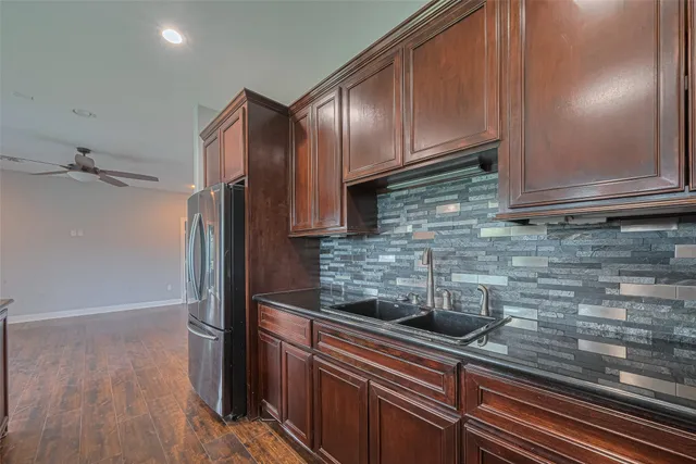 a kitchen with stainless steel appliances granite countertop a refrigerator and a sink