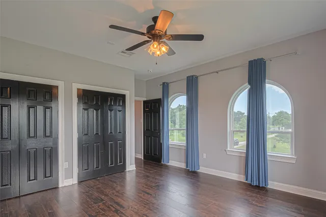 a view of a livingroom with wooden floor and a ceiling fan