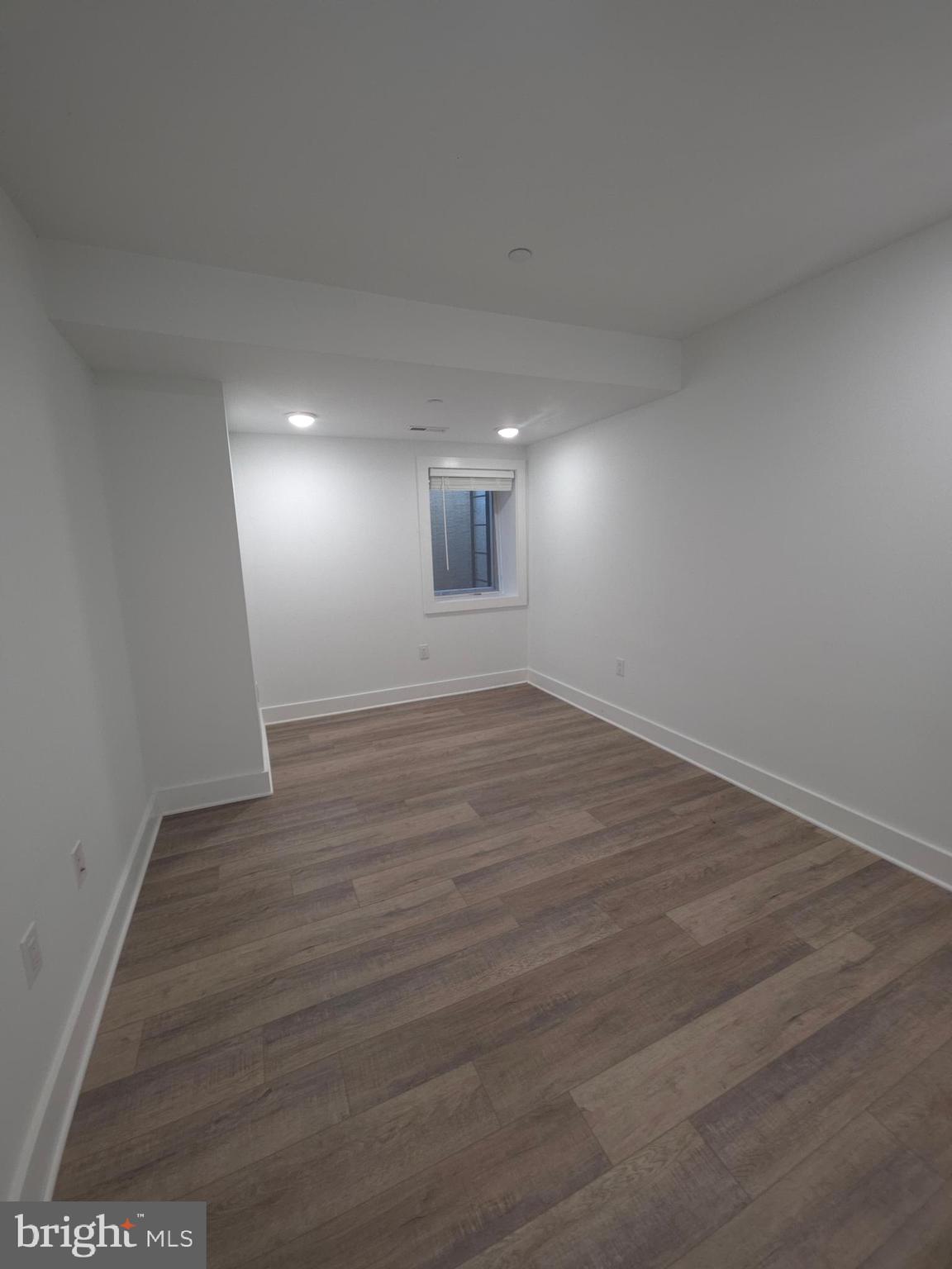 6610 Germantown Avenue, Unit LL6 Philadelphia, PA 19119 - Photo 28 of 38 an empty room with wooden floor and windows