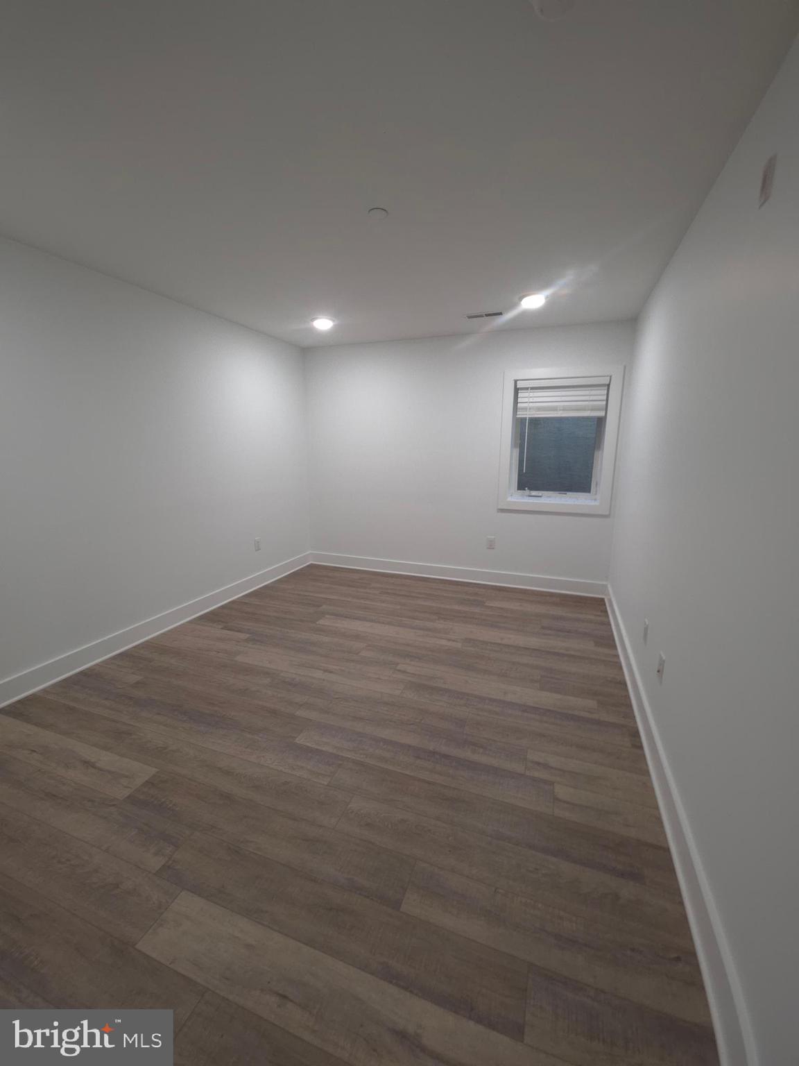 6610 Germantown Avenue, Unit LL6 Philadelphia, PA 19119 - Photo 36 of 38 an empty room with wooden floor and windows