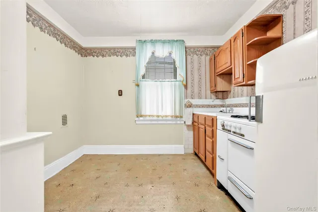 a kitchen with a refrigerator oven stove and a window