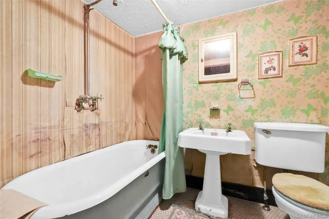 a bathroom with a sink a toilet a mirror and shower