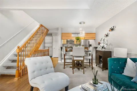 a living room with furniture a dining table and a potted plant